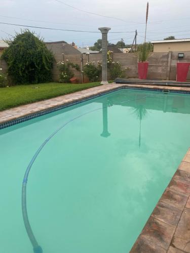 a large swimming pool with blue water in a yard at Black Diamond B&B Guesthouse in Upington