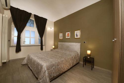 um quarto com uma cama grande e uma janela em La Corte em Alba