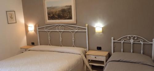 カーヴァ・デ・ティッレーニにあるB&B Da Vincenzoのベッドルーム1室(ベッド2台、壁に照明2つ付)