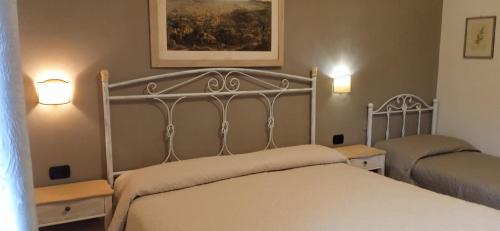 B&B Da Vincenzo في كافا دي تيريني: غرفة نوم بها سرير ومصباحين على الحائط