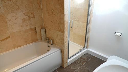 a bathroom with a tub and a toilet and a shower at Merchants Rise in Dartmouth