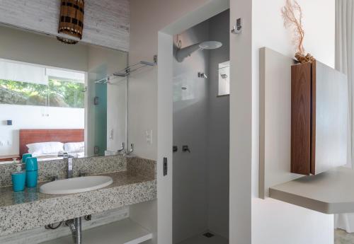 a bathroom with a sink and a mirror at Casa com piscina, deck e vista para o mar in Morro de São Paulo