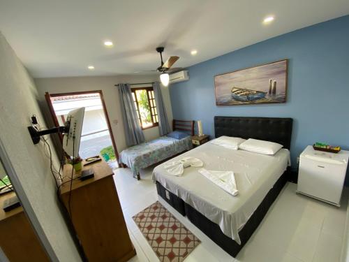 a bedroom with a bed and a living room at Pousada da Pedra in Pedra de Guaratiba