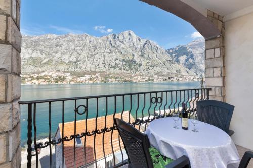 a table and chairs on a balcony with a view of the water at Apartments Vuković in Kotor