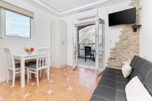 a living room with a couch and a table and a tv at Apartments Vuković in Kotor