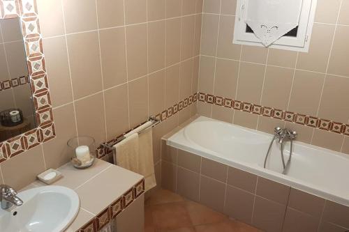 La salle de bains est pourvue d'une baignoire et d'un lavabo. dans l'établissement Les oliviers de Murateddu (Maison individuelle), à Porto-Vecchio