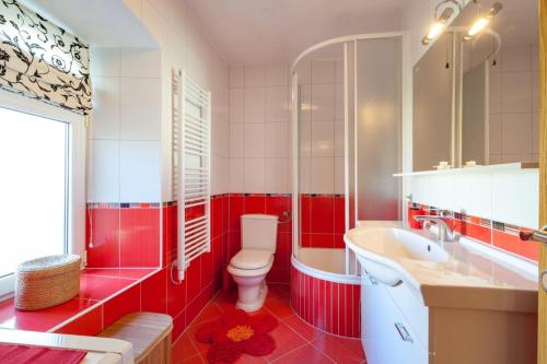 a red and white bathroom with a toilet and a sink at Apartman Dijana in Trogir