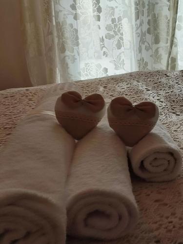 two towels in the shape of hearts on a bed at Casedda Ostunese in Ostuni