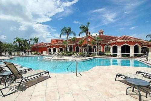 a large swimming pool with chairs and a house at Luxury 5 star Italian Resort Condo 2 bd 2 bath in Clearwater
