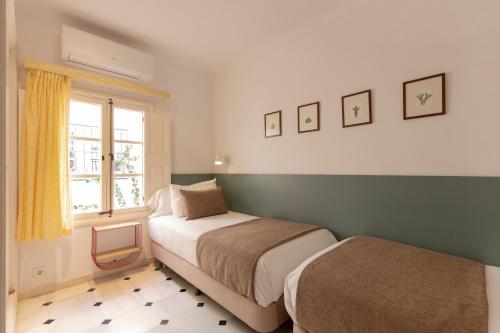 una camera con due letti e una finestra di Villa Ca na Tonina - La Goleta Hotel de Mar & Villas a Port de Pollença