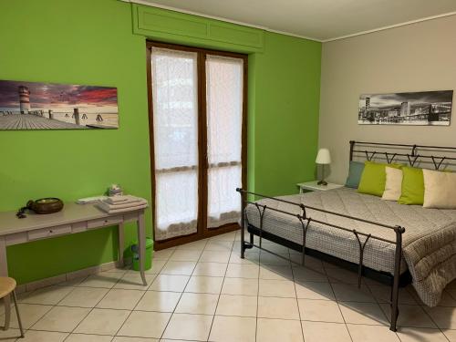 1 dormitorio con paredes verdes, 1 cama y escritorio en I Pini Bed and Breakfast en Boves