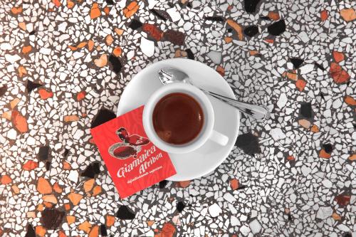 a cup of coffee on a plate on a table at Casa al Sole in Ortisei