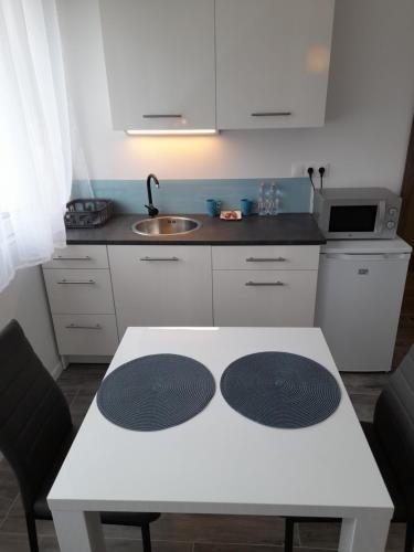 a kitchen with a white table and a sink at Villa Corner in Tihany