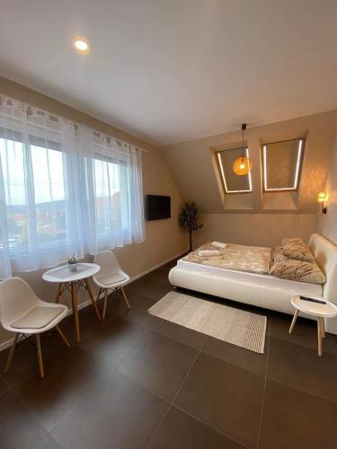 a bedroom with a bed and a table and chairs at Villa Corner in Tihany