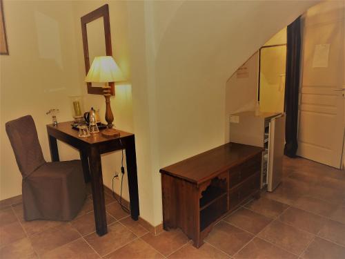 a room with a desk and a chair and a lamp at Chambres d'hôtes La Dorgisane in Venterol