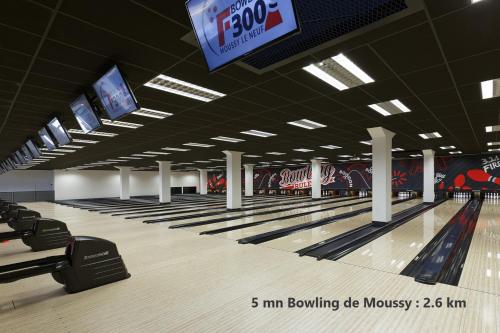a bowling alley with lanes and televisions in a building at studio Orange - Parc Astérix - Mer de Sable - Villepinte - Aéroport CDG in Vémars
