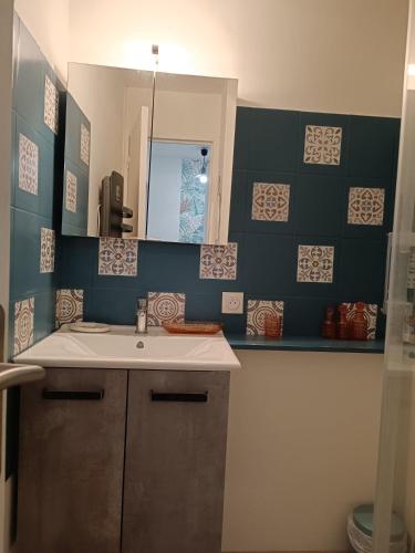 une salle de bain avec un lavabo et un miroir dans l'établissement Les Fées Mer - Dieppe - Normandie, à Dieppe