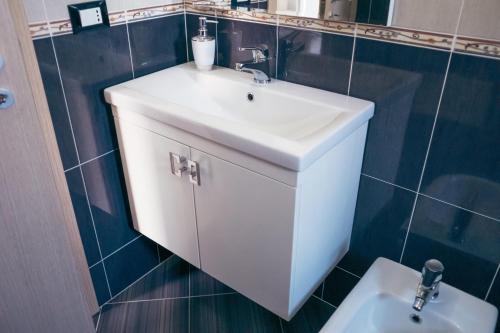 a bathroom with a white sink and a toilet at Blue Paradise Hotel in Orikum