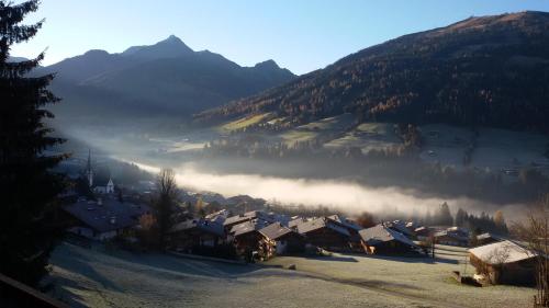a village in the mountains with fog in the valley at Appartement Moaeben in Alpbach