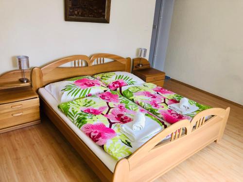 Una cama con flores rosas en una habitación en Apartment Elli, en Františkovy Lázně