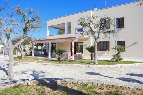 a white house with trees in front of it at VILLA LAURETO - By Apulia Hospitality in Selva di Fasano