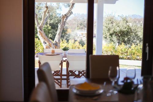 a table and chairs with a view of a window at VILLA LAURETO - By Apulia Hospitality in Selva di Fasano