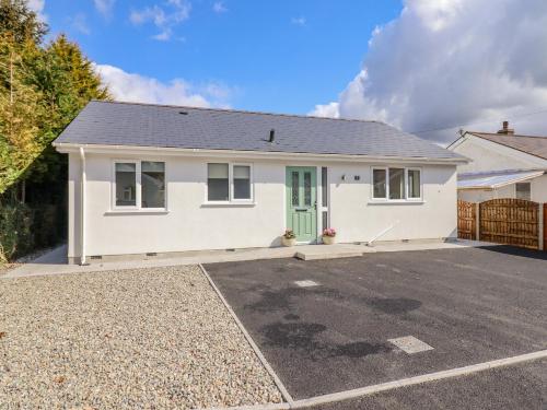 una casa blanca con aparcamiento en Mawnog Fach, en Bala