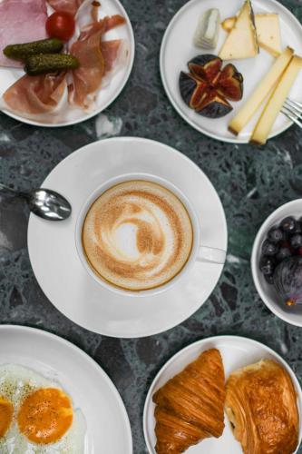 una mesa con platos de comida y una taza de café en Hotel Parister Piscine & Spa, en París