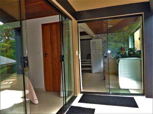 a glass door in a room with a kitchen at MICROCASA DE PRAIA in Angra dos Reis