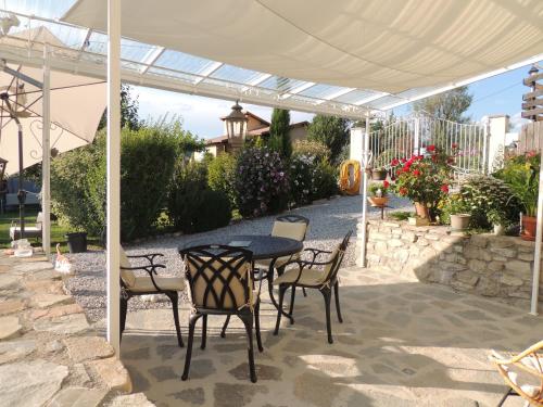 a patio with a table and chairs under a pergola at Chambres d'hôtes La Dorgisane in Venterol