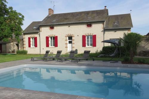 a house with a swimming pool in front of a house at Gîte Les Mirabelles in Saint-Léonard-en-Beauce