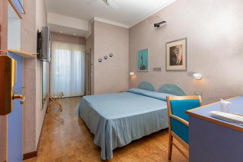 チェゼナーティコにあるHotel Venereのベッドとデスクが備わるホテルルームです。