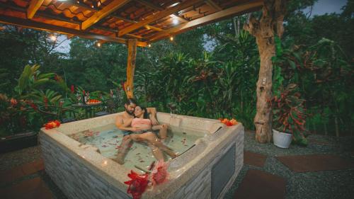 uma mulher sentada numa banheira num jardim em Hotel Rancho Cerro Azul em Fortuna