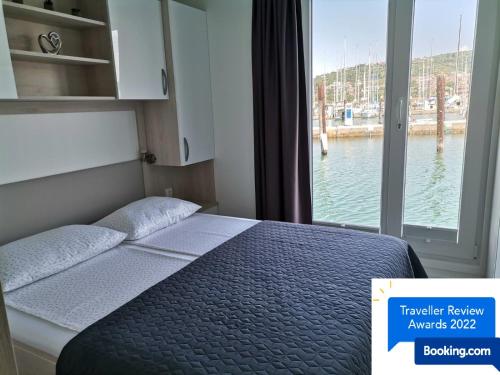 Dormitorio con cama y vistas al agua en Sunset floating house en Portorož