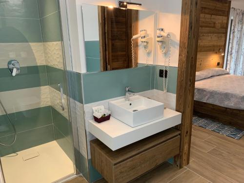 a bathroom with a sink and a shower at Hotel Beau Sejour in Arvier