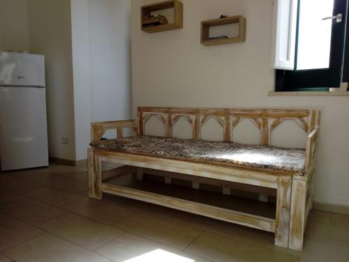 a wooden bench in a room with a refrigerator at Appartamento L'Ammiraglio in Trapani