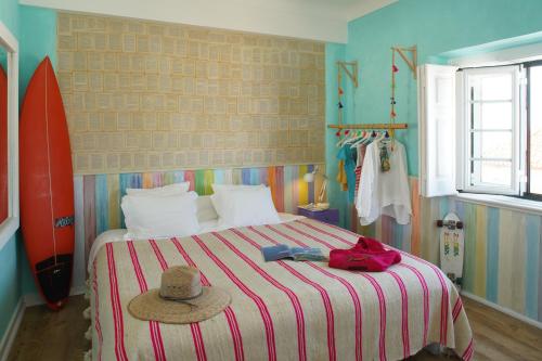 a bedroom with a bed with a hat and a surfboard at Chill in Ericeira Surf House in Ericeira