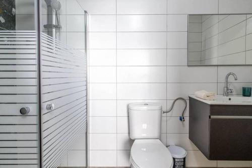 biała łazienka z toaletą i umywalką w obiekcie Blue lake luxury villa for families w mieście ‘Ein el Asad