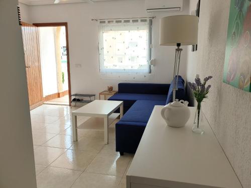 - un salon avec un canapé bleu et une table dans l'établissement 059 Bungalow Torrelamata, à Torrevieja