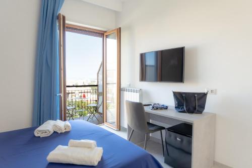 1 dormitorio con 1 cama y escritorio con TV en Le Tre CCC, en Sorrento