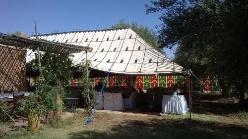 a tent with birds on it in a yard at Chez Kossai Atlas Farm in Chtawna