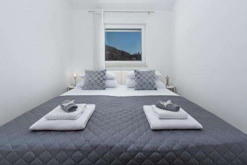 een slaapkamer met een groot bed en 2 handdoeken bij Pelko Apartment in Dubrovnik