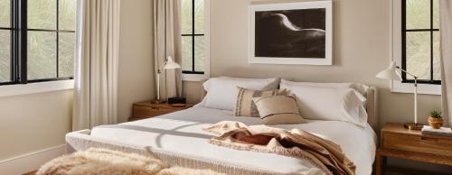 a white bed sitting in a room next to a window at Gurney's Montauk Resort & Seawater Spa in Montauk