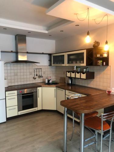 a kitchen with a wooden table and a dining room at Vezas Apartment 3beds in Klaipėda