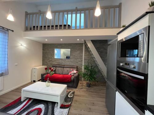 un salon avec un canapé et une télévision dans l'établissement Le Red Loft à 5min du centre-ville avec parking privatif gratuit, à Annecy