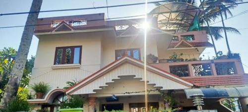 a building with the sun shining in front of it at Mulberry Homestay in Thekkady