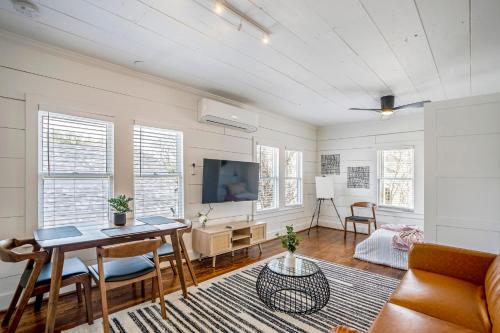 a living room with a table and a tv at Historic Heights Artist Bungalow #3 in Houston