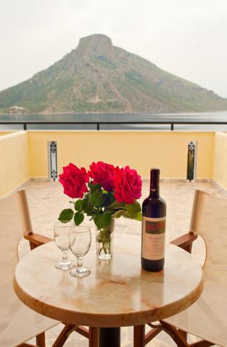 a table with a bottle of wine and flowers on it at Hotel Philoxenia in Masouri