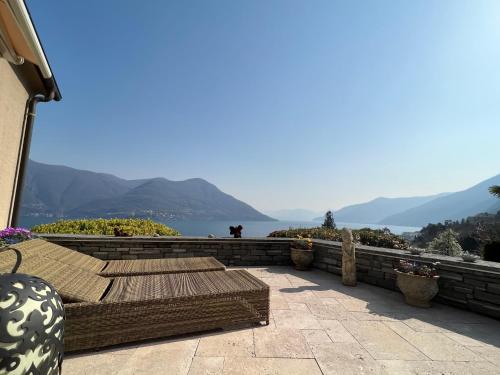 a patio with benches and a view of the water at Brissago: Villa Claudia in Brissago