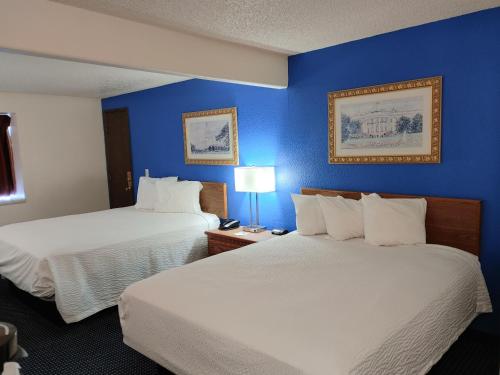 duas camas num quarto de hotel com paredes azuis em Days Inn by Wyndham Pocatello University Area em Pocatello